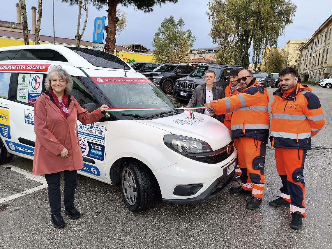 II taglio del nastro con alcuni volontari AGA e, a sinistra, l'assessore ai Servizi sociali Antonella Maucioni