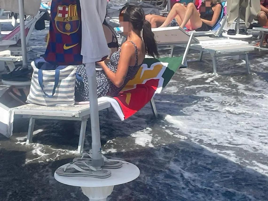 Bagnanti sui lettini con il mare che avanza