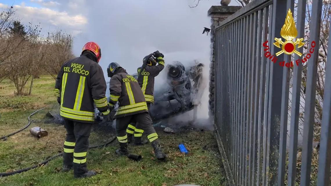 Auto contro la recinzione di una casa, cappotta e prende fuoco