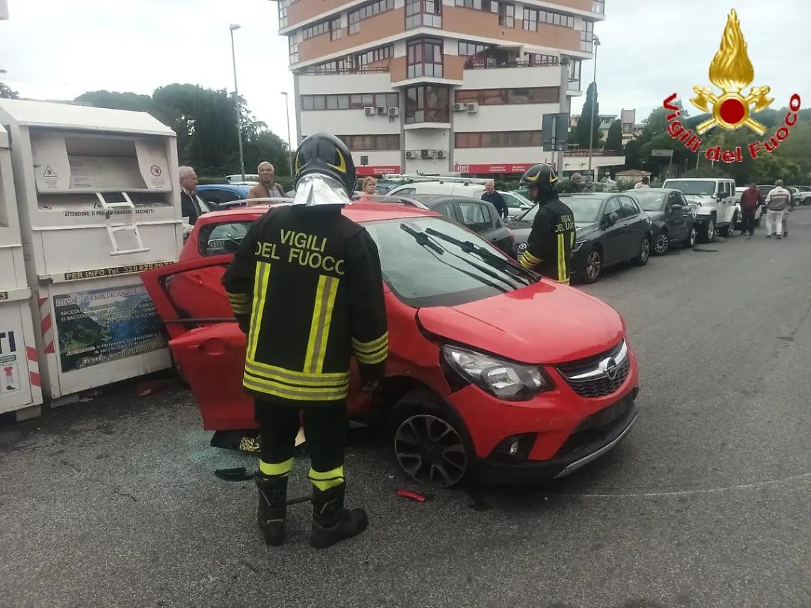 Auto perde il controllo, urta le vetture in sosta e colpisce il raccoglitore di abiti usati
