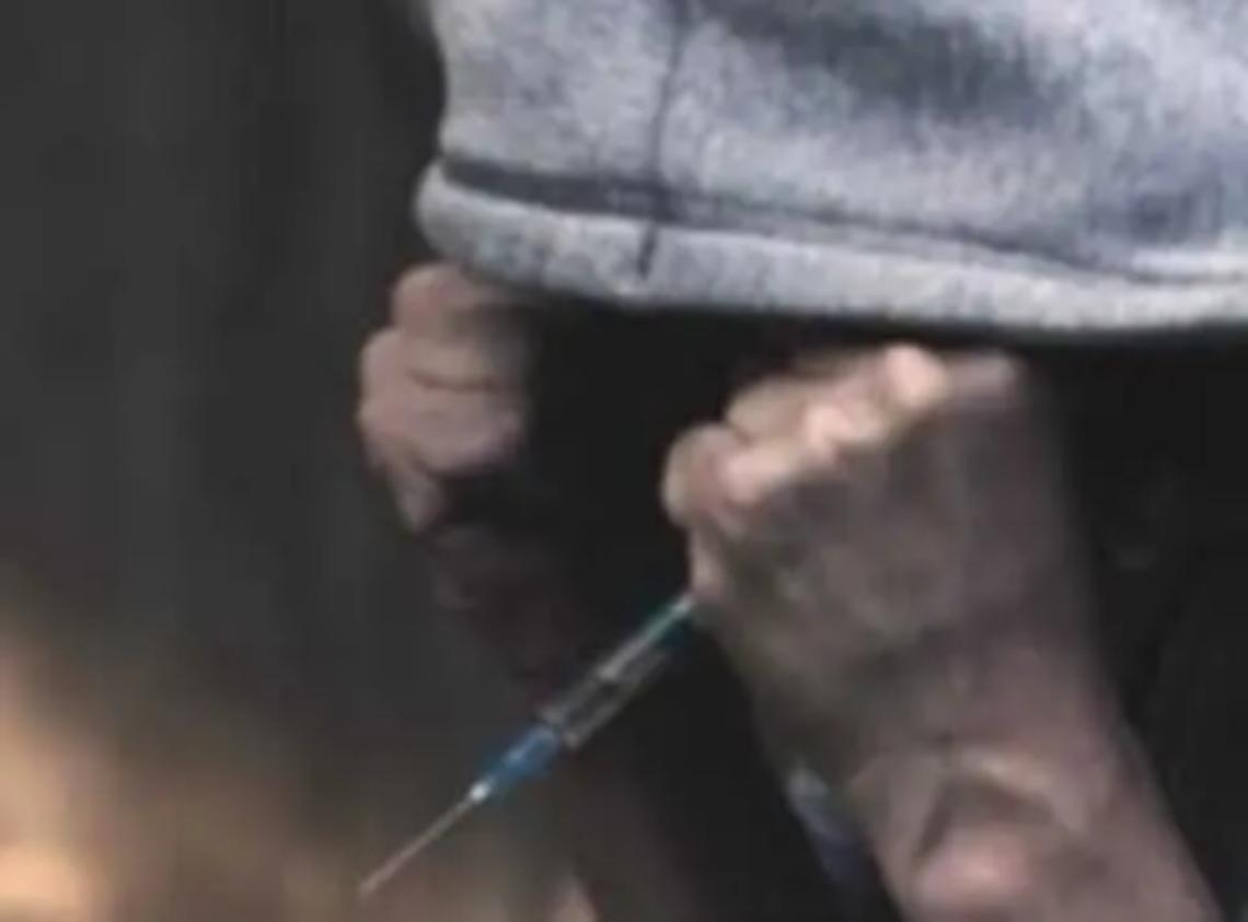 Minaccia un commerciante con una siringa sporca di sangue