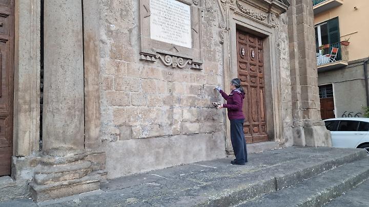 Scritte santaniche sulla chiesa di San Faustino, una fedele le ricopre